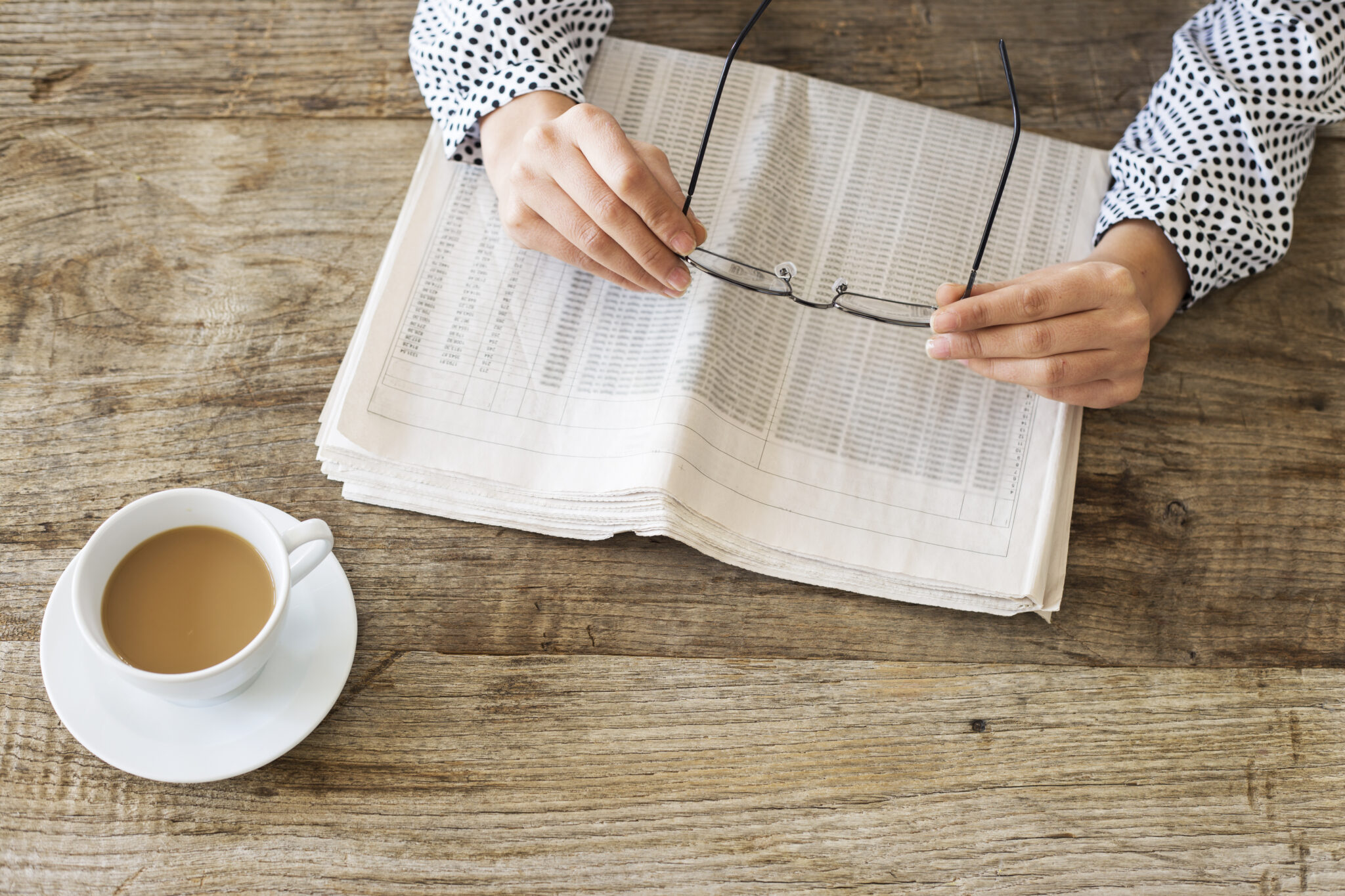 Reading Newspaper On Wooden Table